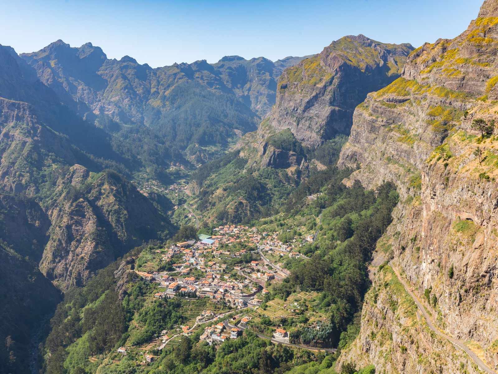 Curral das Freiras village deep in its valley, ringed by steep green peaks, seen from Eira do Serrado