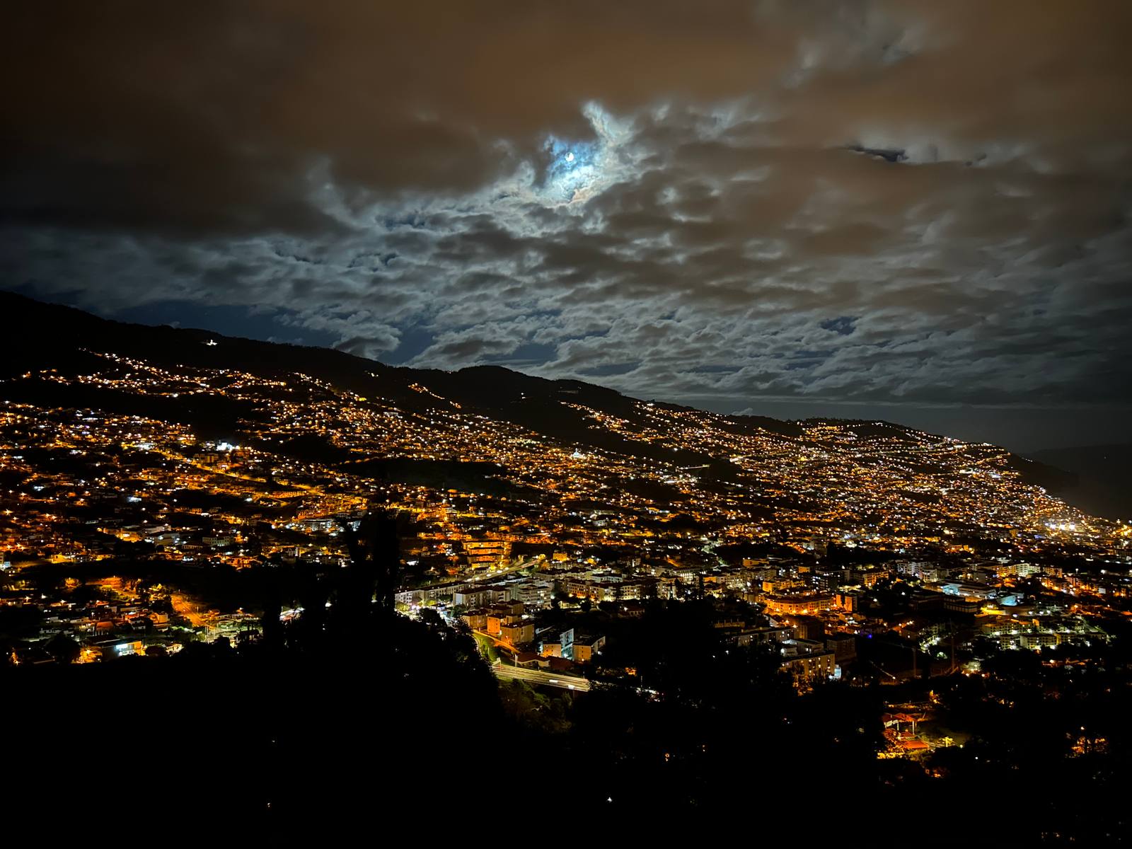 Funchal at night from Pico dos Barcelos, the lights of the city climbing the hills under a cloudy sky