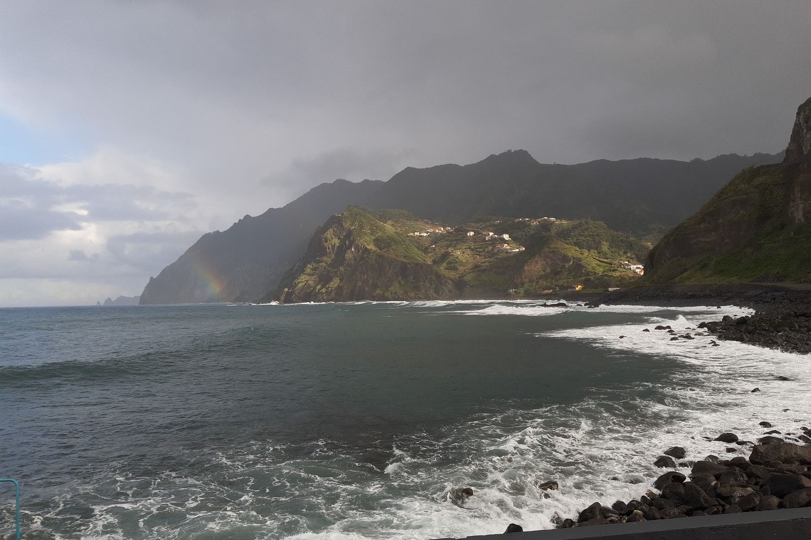 Waves breaking on the beach at Porto da Cruz under the Penha d'Águia cliff
