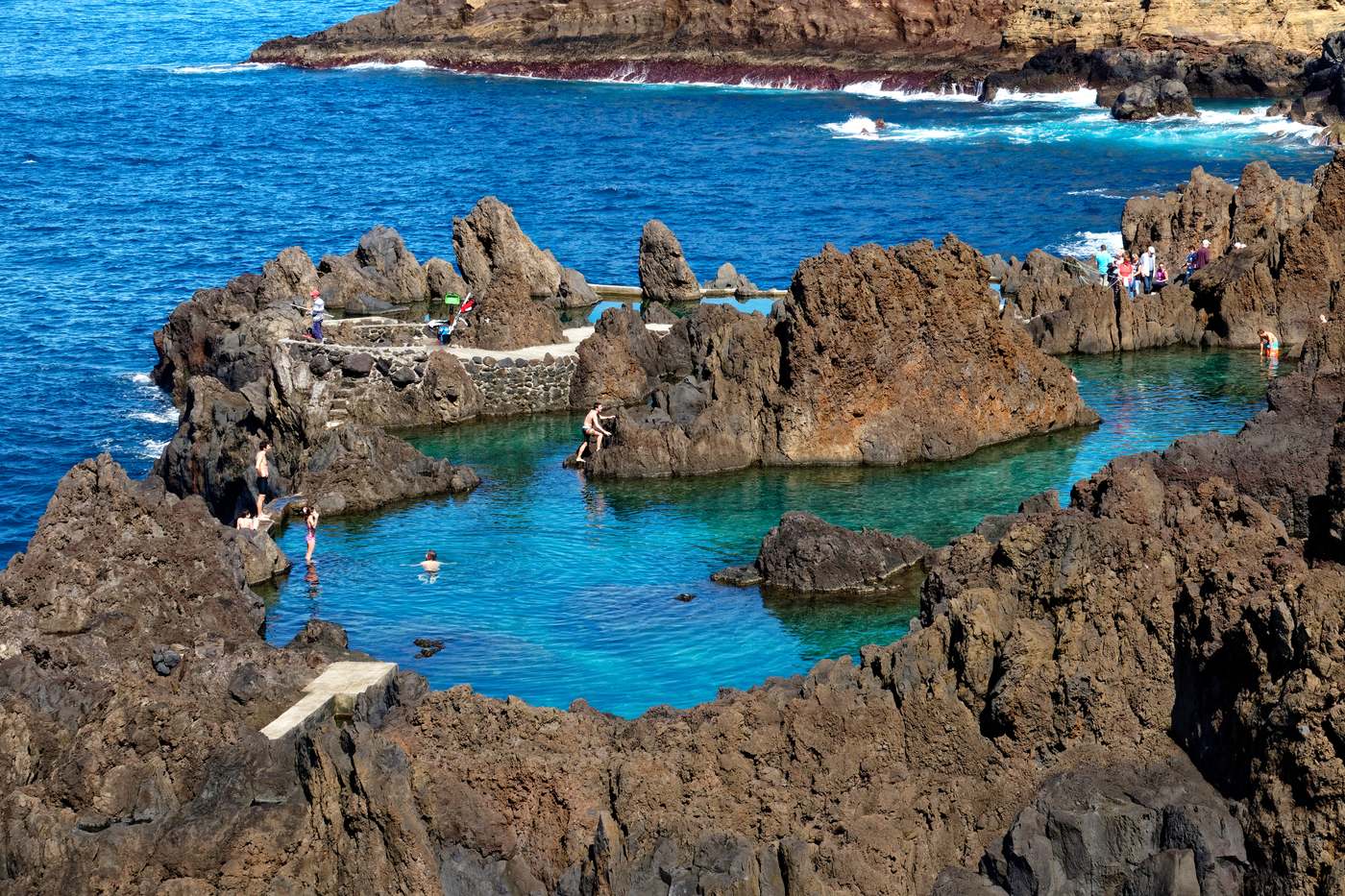 A turquoise natural pool between black lava rocks at Porto Moniz