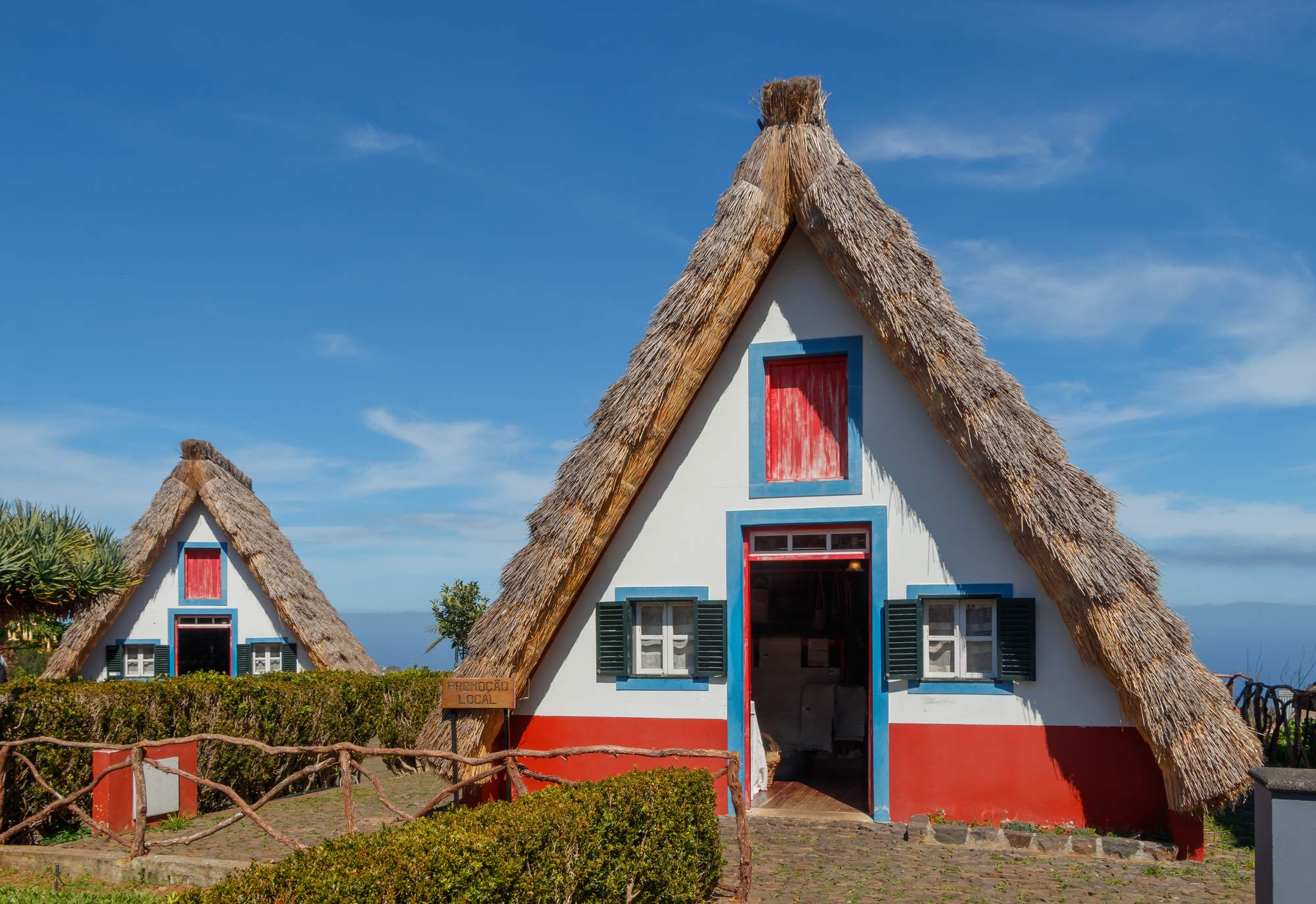 Two thatched A-frame houses in Santana under a clear sky